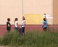 Школьники из трудового лагеря «Рабочий» закрашивают надписи и рисунки на фасадах домов